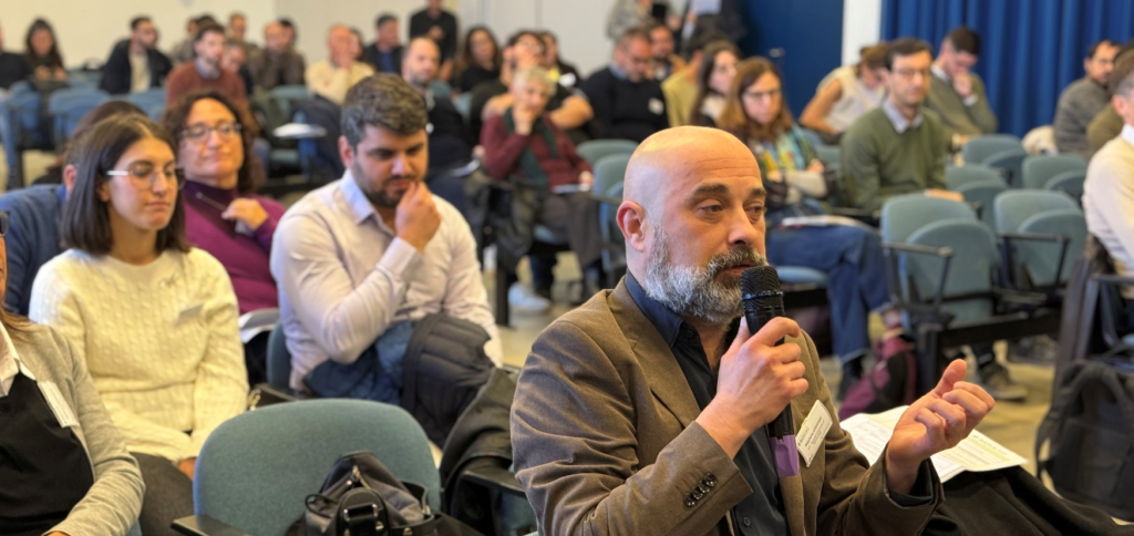 Image depicts the audience of the BIOVEXO Final Event and a participant asking a question to the speaker.